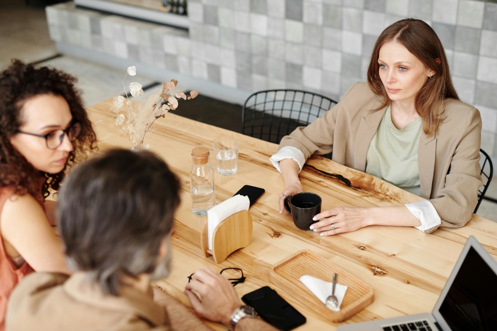 Professional meeting at a cafe table with laptop and coffee — your public CoffeeChat profile